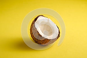 Single coconut fruit on yellow plain background, abstract food tropical concept