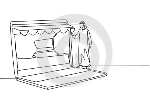 Single continuous line drawing Arabian man inserting credit card into canopy laptop screen with shopping cart. E-shop, digital