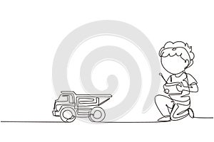 Single continuous line drawing boy playing with remote-controlled dump truck toy. Cute kids playing with electronic dump truck toy