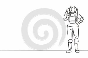 Single continuous line drawing female astronaut stands with thumbs-up gesture wearing space suit exploring earth, moon, other