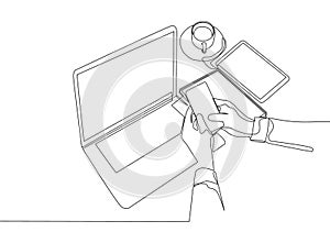 Single continuous line drawing of hand gestures holding and touching a smartphone screen with laptop, cup of coffee and tablet