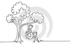 Single continuous line drawing happy two boys playing tire swing under tree. Cute kids swinging on tire hanging from tree.