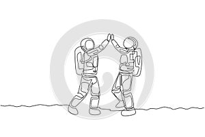 Single continuous line drawing of two young astronauts giving high five gesture to celebrate a success in moon surface. Space man