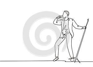 Single continuous line drawing of young happy male pop singer holding microphone and singing on music festival stage. Musician