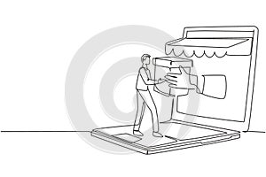 Single continuous line drawing young man receives package box from large canopy laptop screen and hands it over. Digital delivery