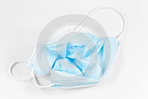 A single crumbled surgical masks isolated on white background