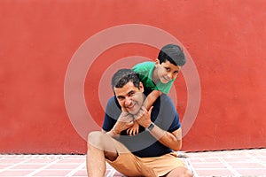 Single dad and dark-haired Latino son play and have fun together spending quality family time on Father`s Day celebrating victory