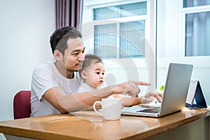 Single dad and son using laptop together happily. Technology and