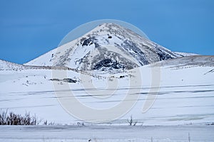 Single dramatic symetrical volcanic,snow covered cone near lake Myvatn, Iceland