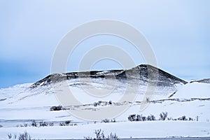 Single dramatic symetrical volcanic,snow covered crater near lake Myvatn, Iceland