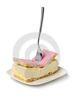 Single Dutch Tompouce pastry broken by a fork on white background close up