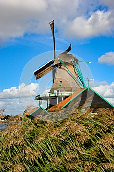 Single Dutch Windmill with beautiful puffy white clouds in the background of The Netherlands.