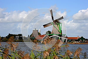 Single Dutch Windmill with beautiful puffy white clouds in the background of The Netherlands.