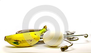 Single egg banana and stethoscope isolated in white background as doctor recommendation health and nutrition purpose with room for