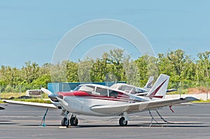 Single engine, private airplane secured on tropical tarmac