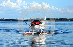 Single engine seaplane on blue waters and blue skies in the background. . photo