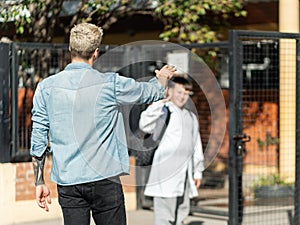 Single father saying goodbye to his son at the front of the school in Argentina