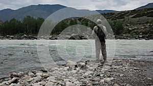 Single fisherman on a stormy river is fishing on a sunny summer day