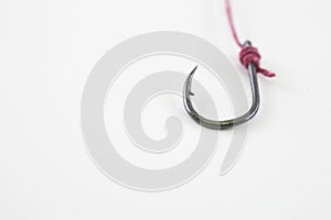 single fishing hook hooked with red rope on a white background