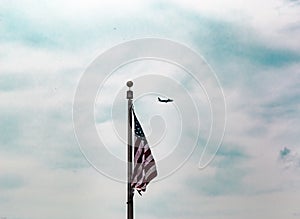 Single flag flying with a plane passing by