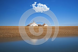 Single fluffy cloud over lone cottage