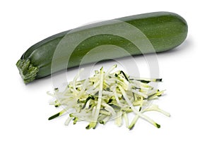 Single fresh green whole zucchini and noodles on white background