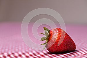 Single Fresh Strawberry On Red Gingham Tablecloth
