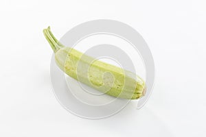 Single fresh whole green zucchini isolated on white background with shadow