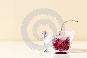 Single frozen cherry in ice cube. Horizontal template for banner, poster, copy space. Preservation of summer vitamins. Concept of