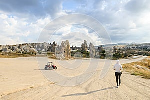 Single girl waling toward ATV in valley of Cappadocia