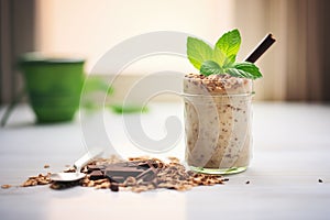 a single glass of chocolate banana oats with a mint leaf, morning light cast