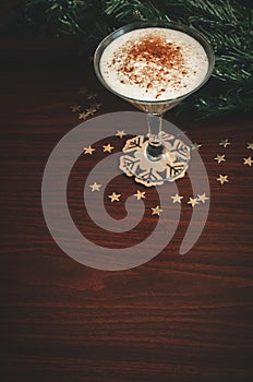 Single glass of eggnog on the wooden table vertical christmas background with copy space