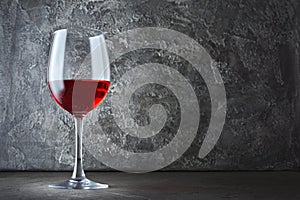 Single glass of red wine for tasting in dark cellar with copy space