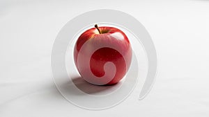 A single glossy red apple is centered on a plain white background