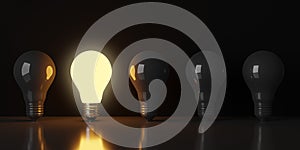 Single glowing light bulb in row of dark bulbs over black background, creativity, uniqueness or standing out concept