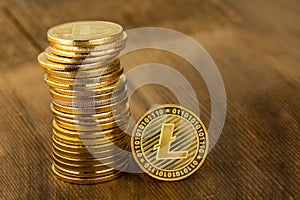 Single gold Litecoin coin alongside a stack