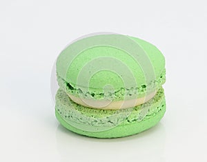 single green-colored macaron on white background