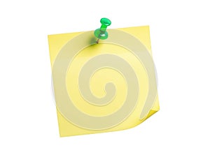 Single green pushpin securing yellow note