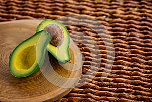 Single green raw severed avocado which is cut to two halves.