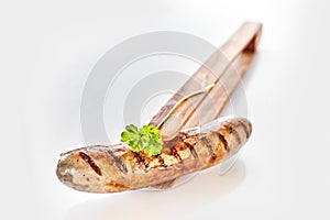 Single grilled pork sausage presented with thongs