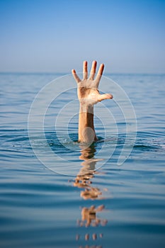 Single hand of drowning man in sea asking for help