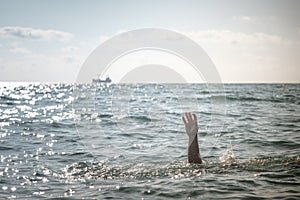 Single hand of drowning man in sea asking for help