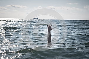 Single hand of drowning man in sea asking for help