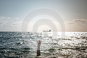 Single hand of drowning man in sea asking for help