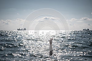 Single hand of drowning man in sea asking for help