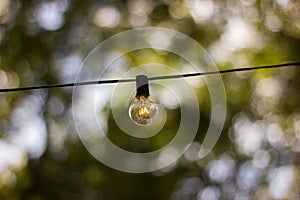 A single hanging lightbulb outside, exterior decoration