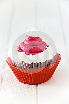 Single homemade chocolate cupcake with frosting white pink cream cheese. Isolated.