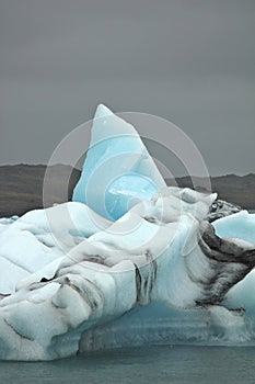 Single iceberg against dark sky