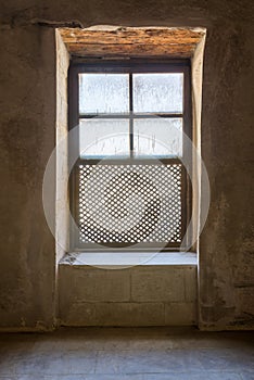 Single Interleaved grunge wooden ornate window - Mashrabiya - in stone wall at abandoned building photo