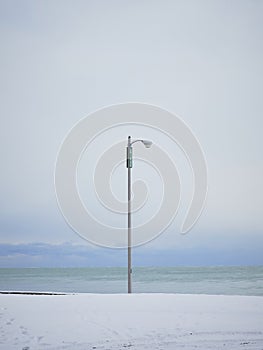 Single lamppost on snowy beach